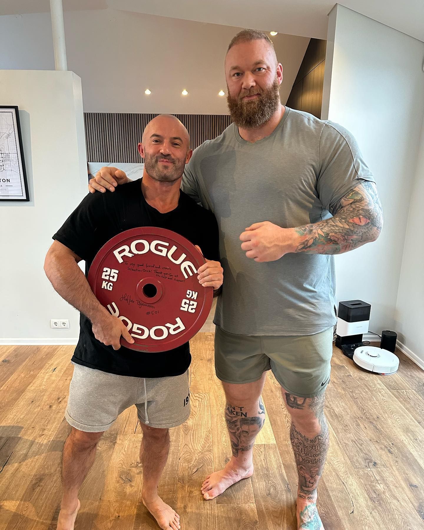 Sebastian Oreb and Thor Bjornsson pose with a weight plate