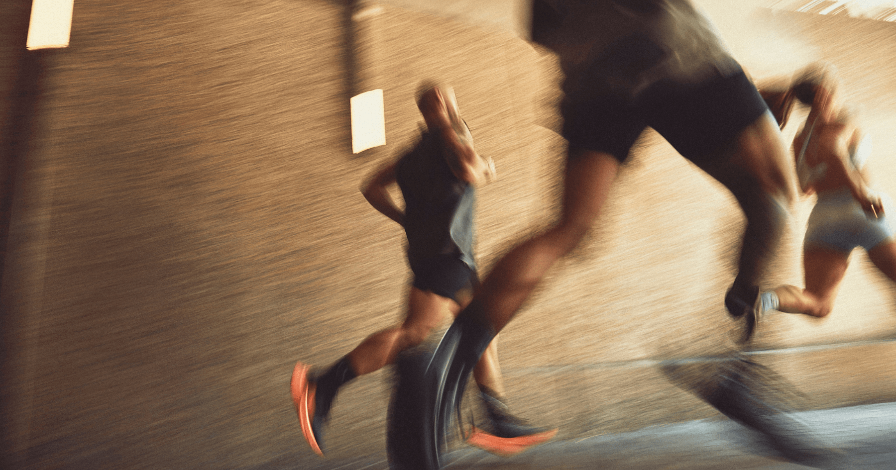 Blurred image of the back of three people running